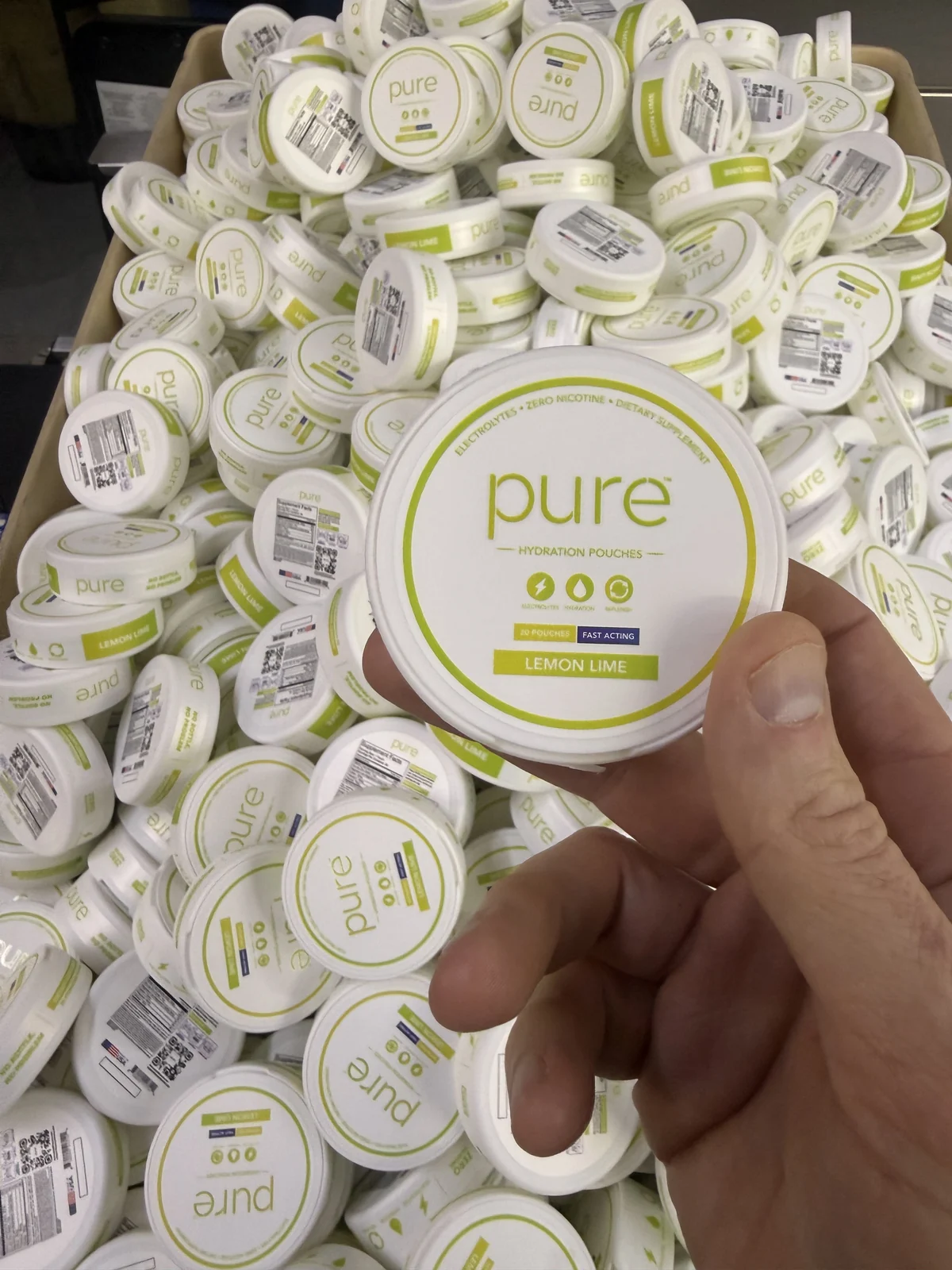 Finished lemon lime hydration pucks, with one puck held above a production batch