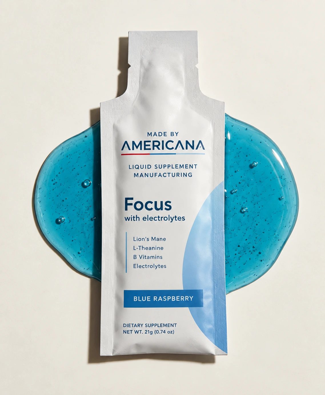 Made By Americana Blue Raspberry Focus liquid supplement sachet with a blue liquid backdrop